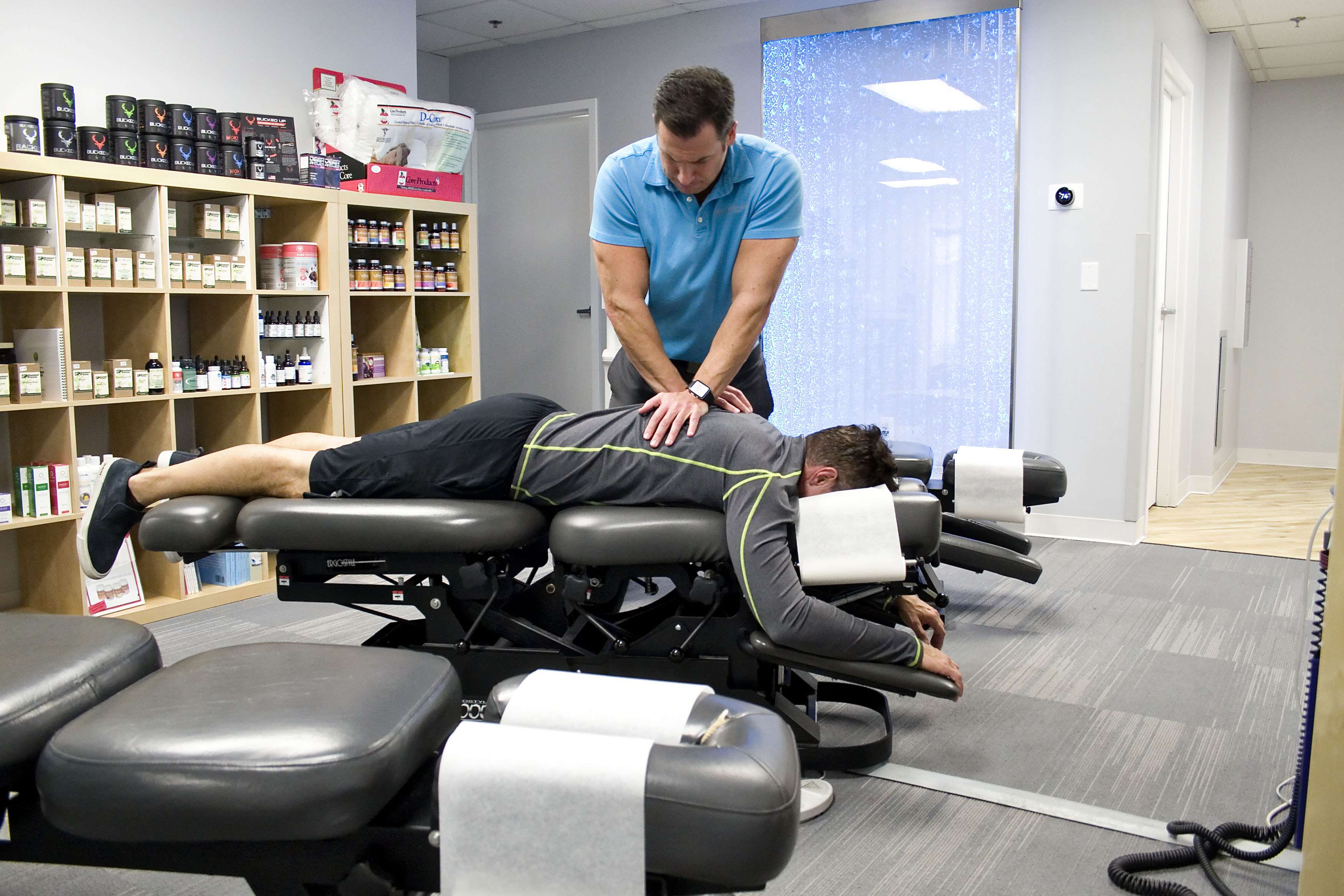 Chiropractor Draper Dr. Gordon LeSueur performing chiropractic adjustment for back pain on man lying face down